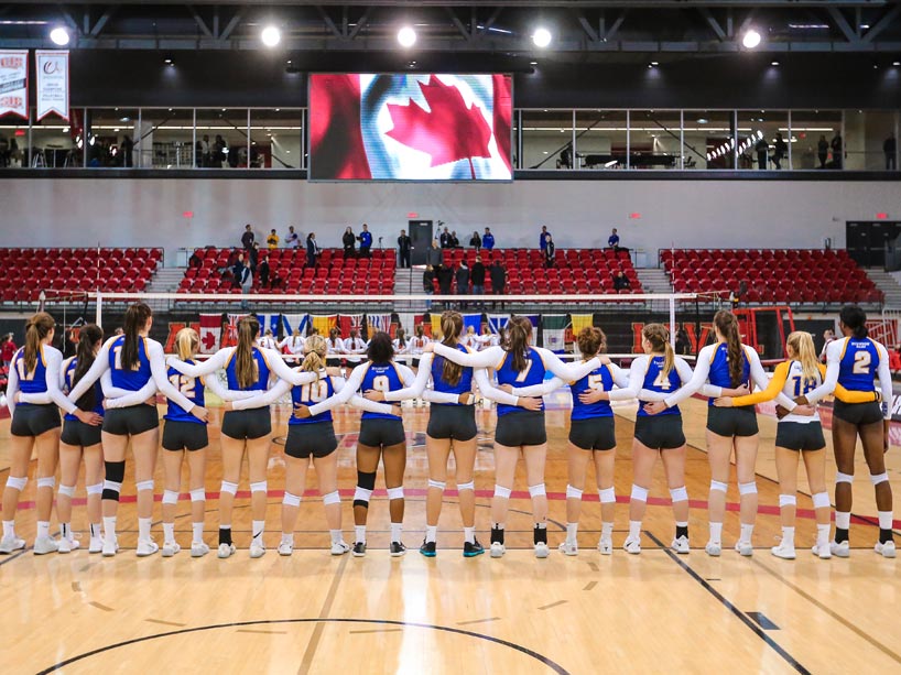 Rams women's volleyball team standing for the national anthem at the national championship