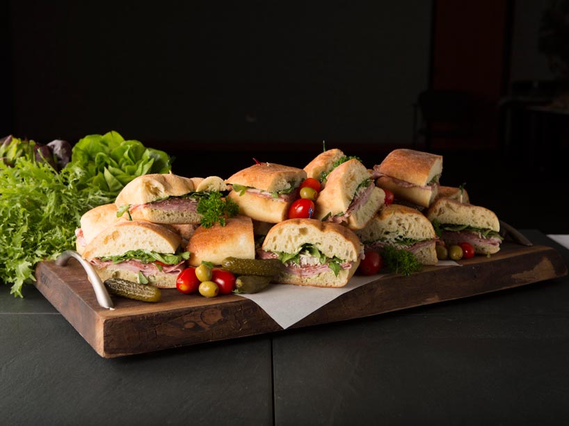 Sandwiches laid out on a wood cutting board