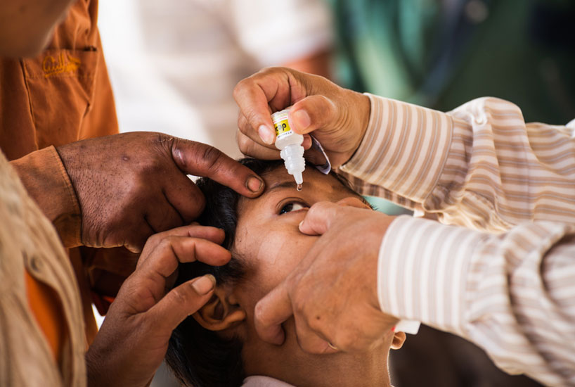 Young boy being given an eye-drop