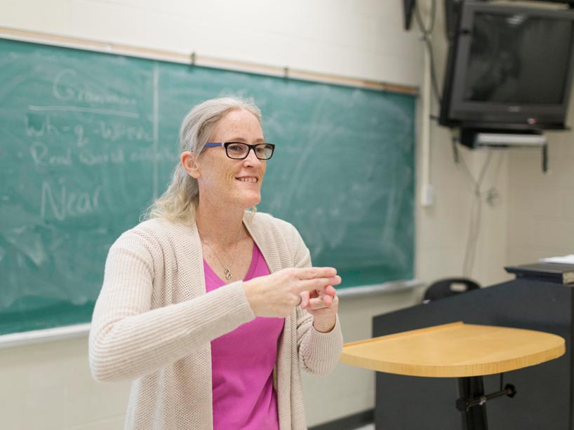 Instructor Nina Winiarczyk signing at the front of class