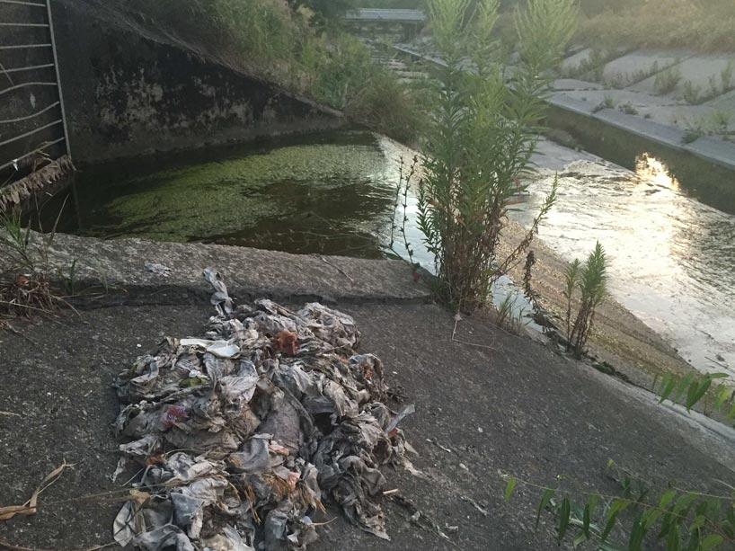 A pile of garbage on concrete near a ravine