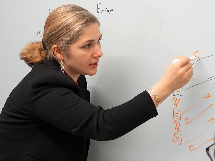 Atty Mashatan writes on a white board with an orange marker