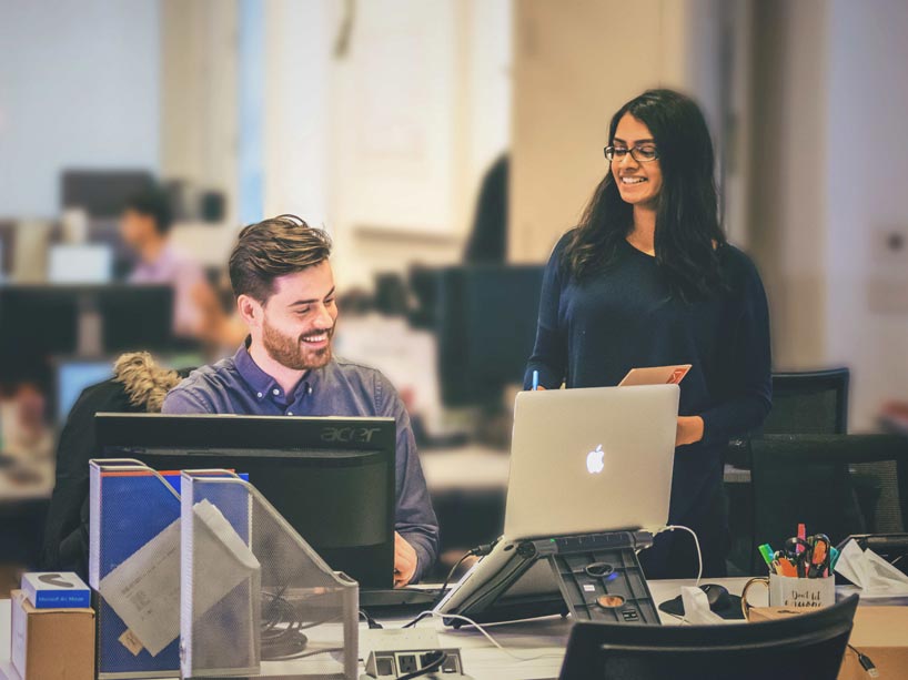 Male and female students working together at computers