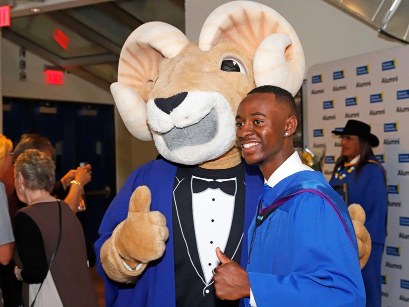 Eggy the Ram and a new graduate giving the thumbs up
