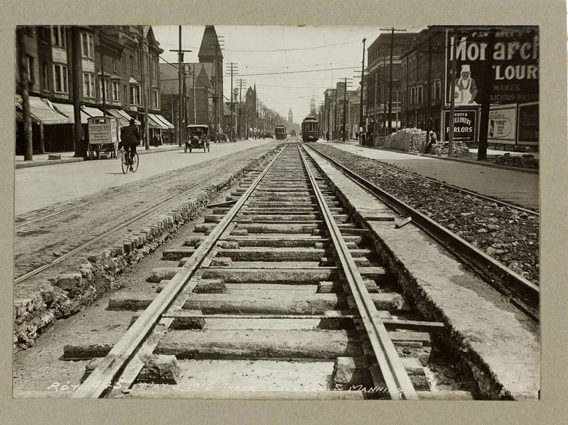 A black and white photo taken at streetcar-track level, looking up College street in 1915