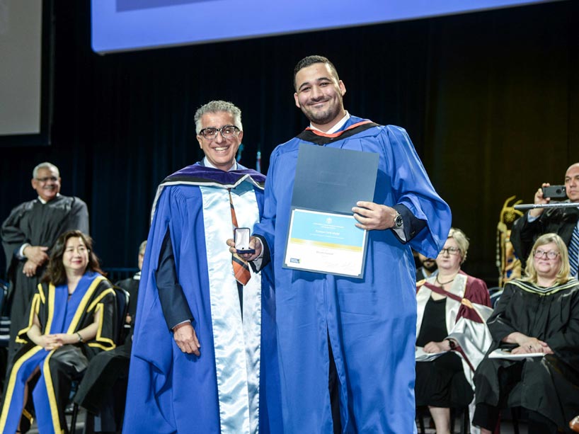 From left: Michael Benarroch and Hosam Sennah, holding his award on stage