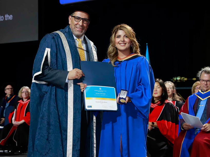 From left: Mohamed Lachemi and Niloufar Rostam Shirazi, holding her award on stage