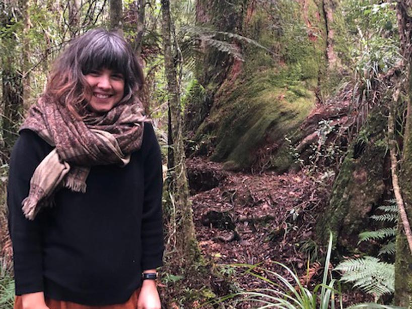 Rachel Bach stands in a forest near Aotearoa, New Zealand