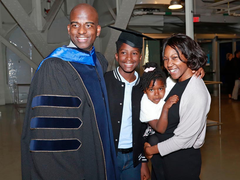 From left: A new graduate stands with his family at convocation