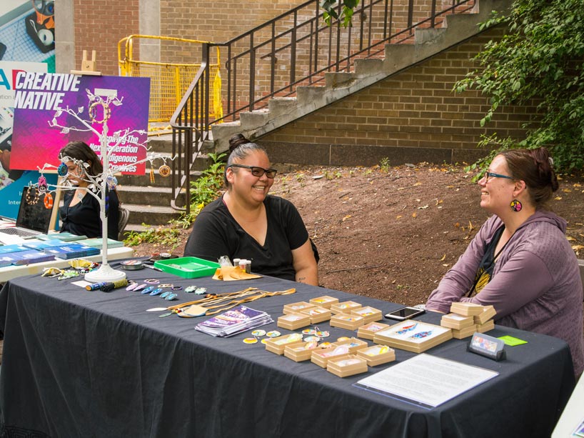 Two women talk while sitting at a table