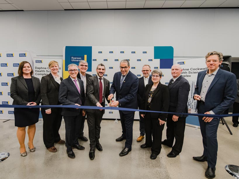 Senior leaders, federal minister and construction representatives standing in line to cut ribbon