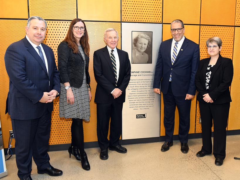 Senior university officials with Jack Cockwell pose in front of plaque commemorating Daphne Cockwell