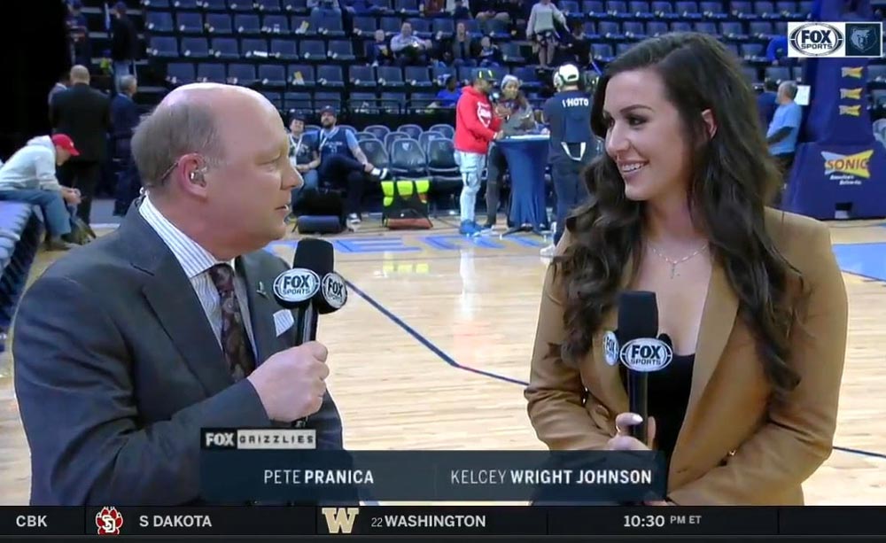 Two sports commentators speaking to each other courtside on-air