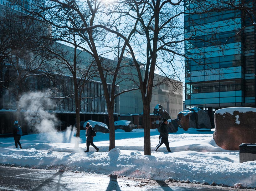 Three students walking in front of Lake Devo