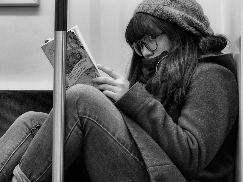 Sitting student reads a book