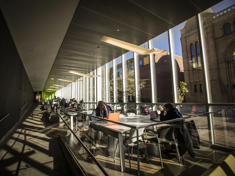 Students work on laptops at tables in the Image Arts Commons