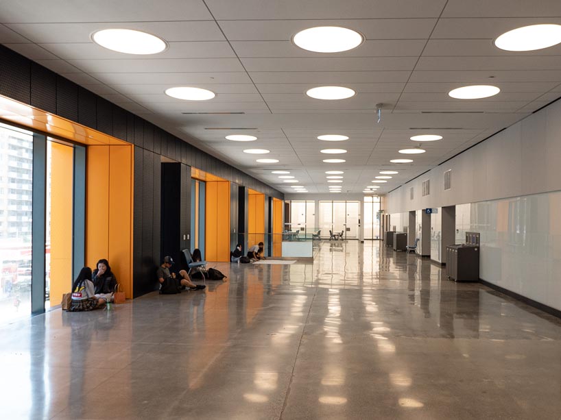 Students sitting on the floor working in a hallway