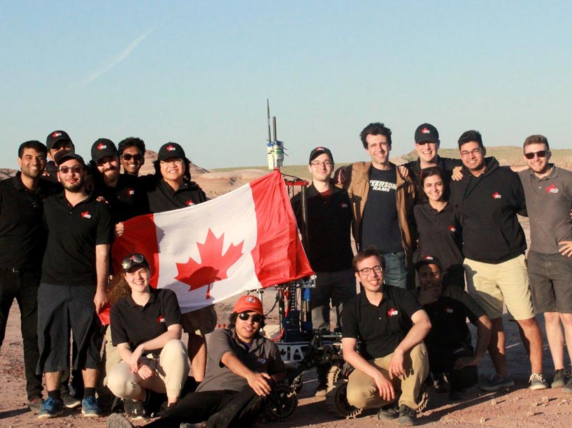 Members of the Ryerson Rams Robotics Team stand with the Mars Rover robot