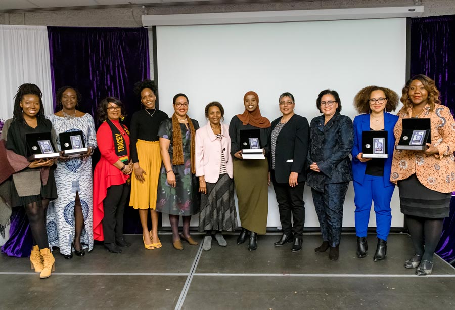 Women standing side by side smiling holding their awards