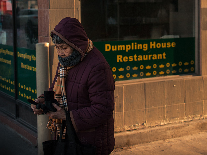 elderly woman walks past Chinese restaurant