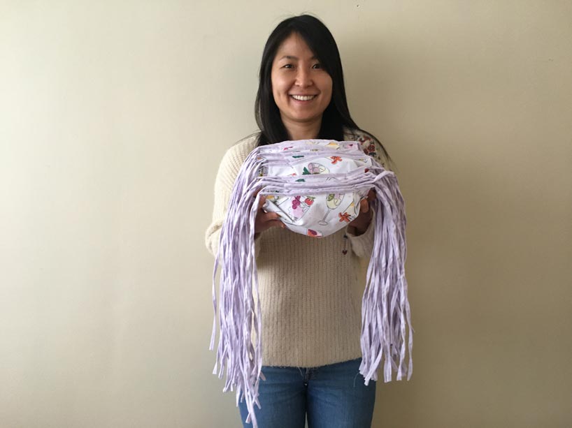 Student holds a pile of masks in her hands