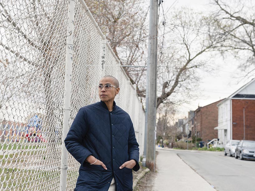 Michèle Pearson Clarke stands by a fence.