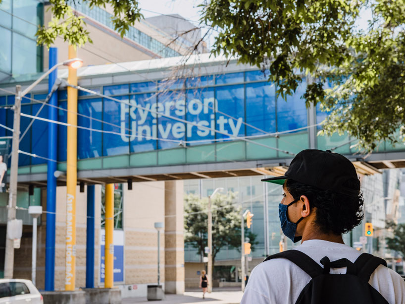 Student walking on campus wearing a mask