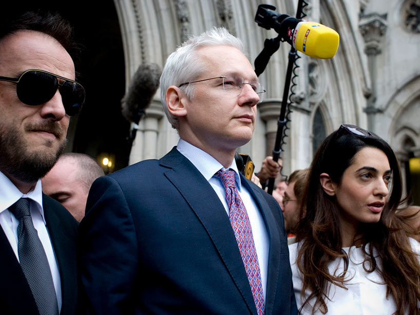 Julian Assange looking out over a crowd of people with cameras