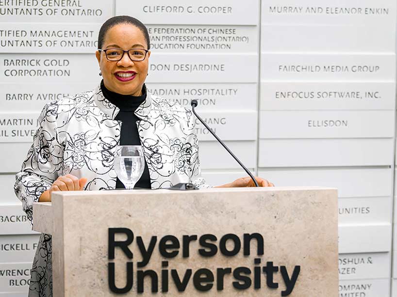 Denise O’Neil Green smiling and standing behind a podium