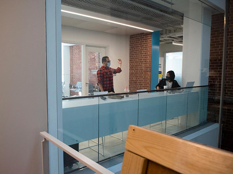 A man stands inside a lab wearing a face mask