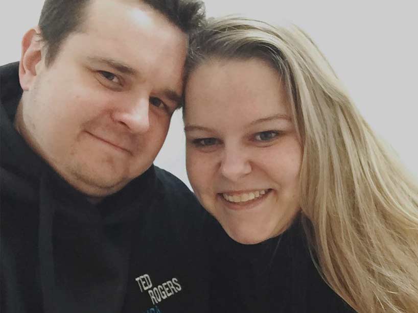 Val Bruce and her fiance smile for the camera in matching Ryerson MBA sweatshirts.