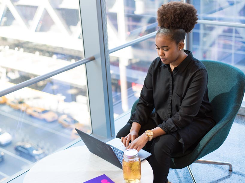 A woman works on her laptop at a table