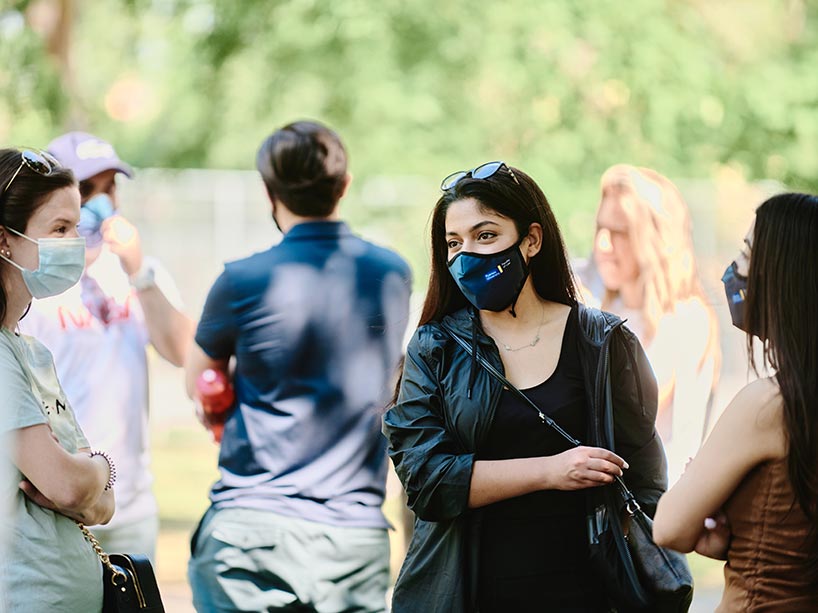Students talking outside with masks on. 