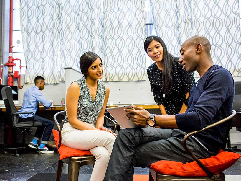 A group of racialized students sit at a table in discussion.