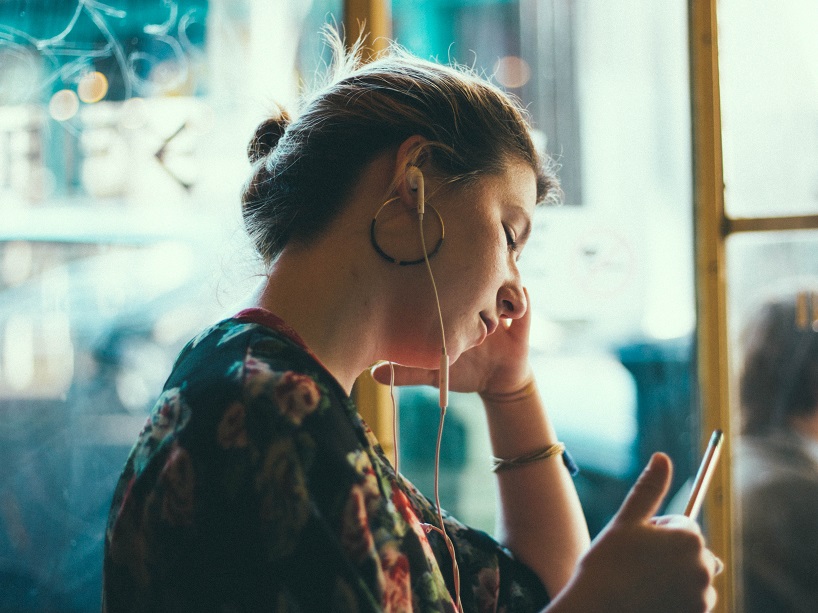 Woman in distress listening to music through earphones.