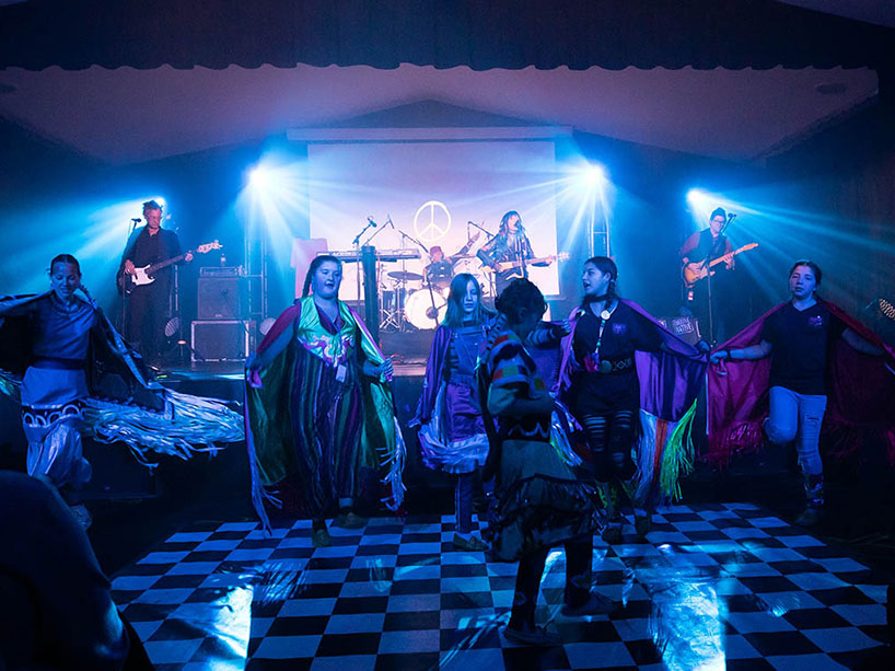 Indigenous youth participants play instruments on stage and dance in costume as part of last year’s Creative Native finale show.