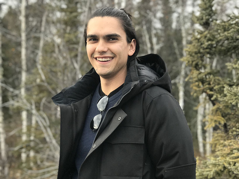 Riley Kucheran standing in a forest.