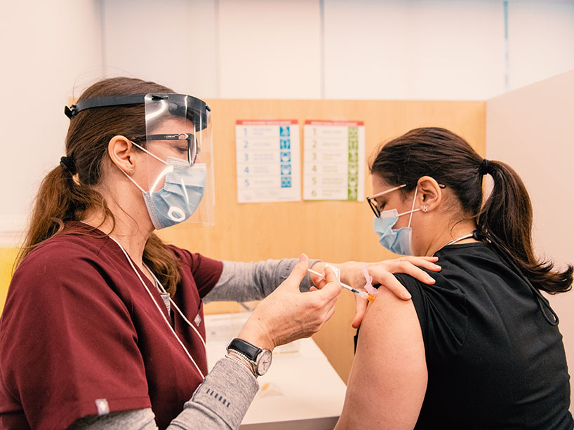 Ryerson professor Nancy Walton administering a vaccine dose.