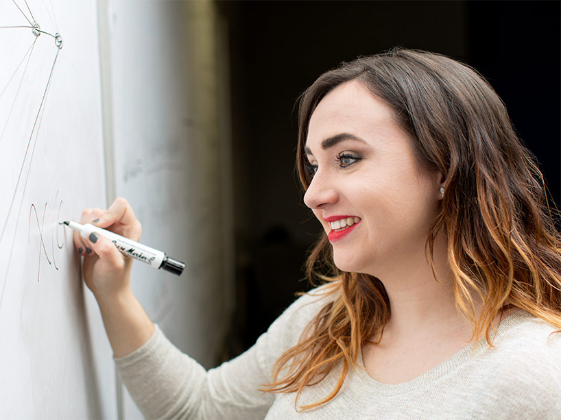 Erin Meger writing on a whiteboard. 