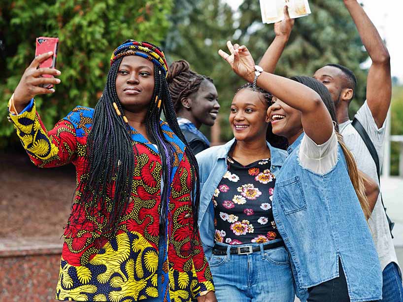 Five Black students posing for a selfie.