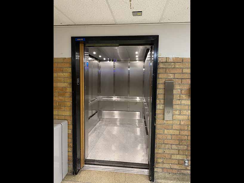 Entrance to a modern elevator with silver interiors.