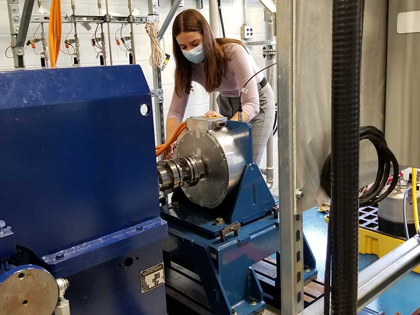 Madeline McQueen adjusts an electric motor in a laboratory. 