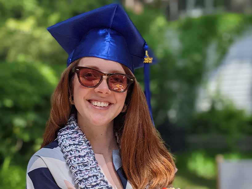Young woman wearing blue graduation cap.