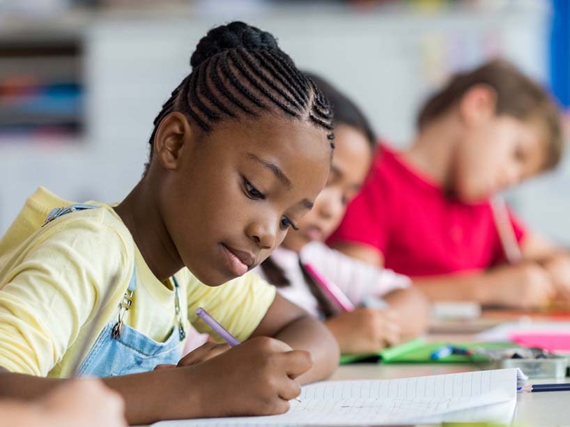 A student writing on a piece of paper.