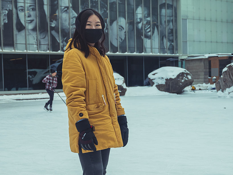 A student on campus with a mask on.