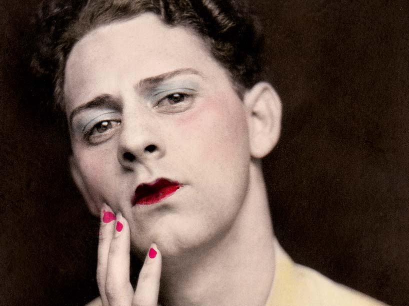 Man wearing red lipstick and blue eyeshadow in portrait. 