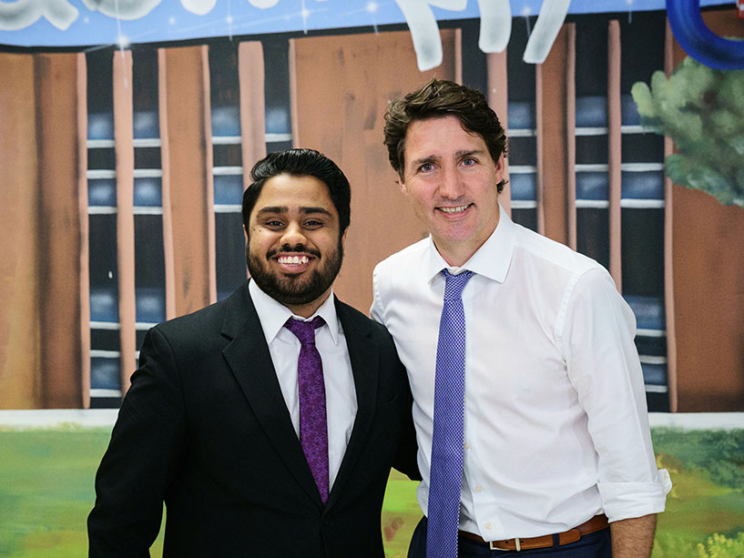Student Ali Areesh Somani poses next to the Canadian Prime Minister