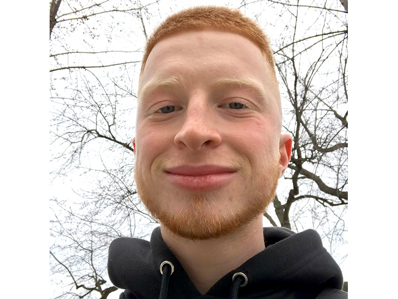 Stefan Mumford Marilovic in a black hoodie against a background of trees.   