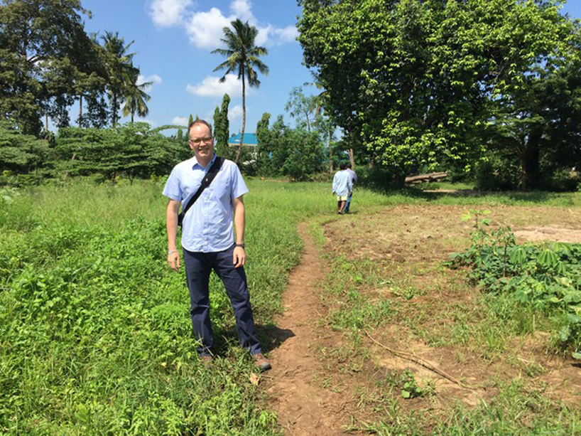 Christopher Gore standing at an agricultural research station in Tanzania..
