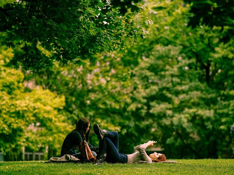 Two students laying in grass in the Kerr Hall quad.